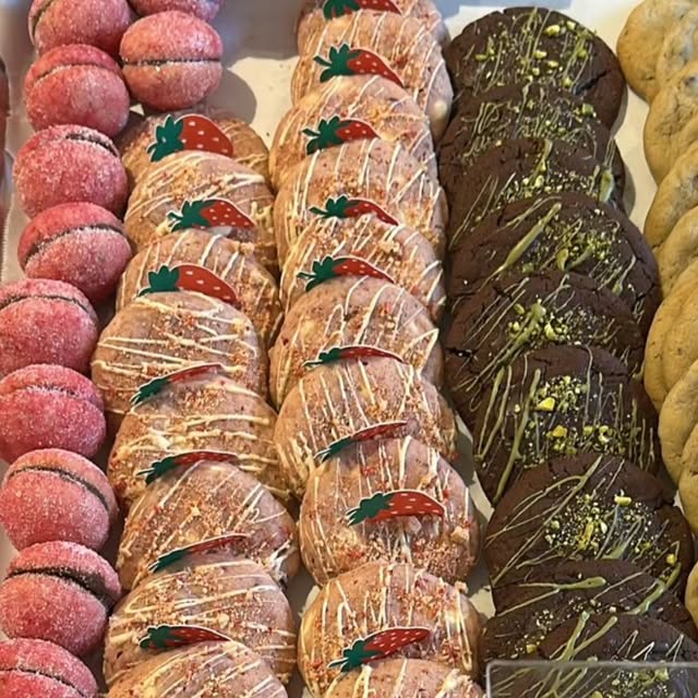 Strawberry-topped and pistachio-drizzled cookies lined up on a tray