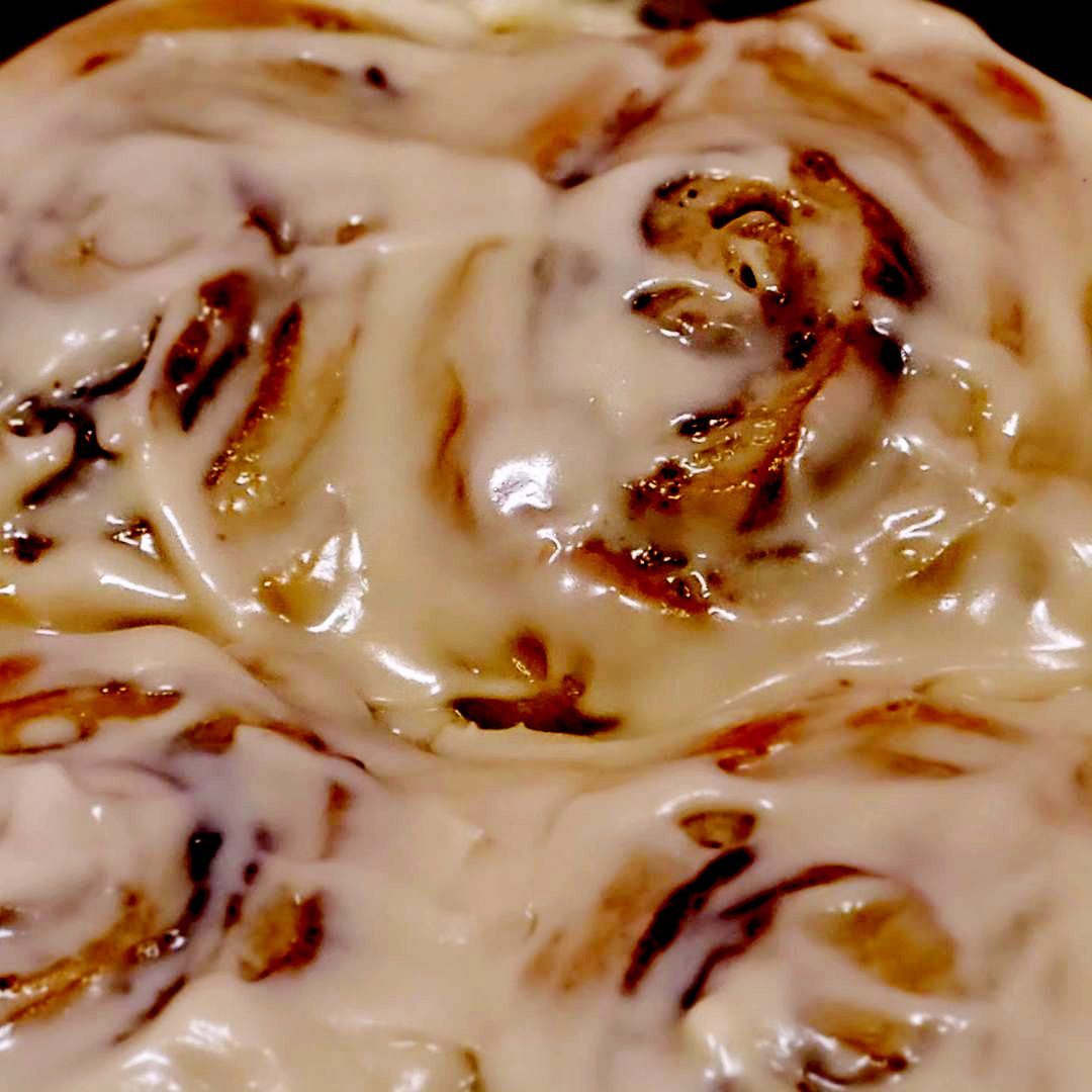 Close-up of a cinnamon bun under cream cheese glaze
